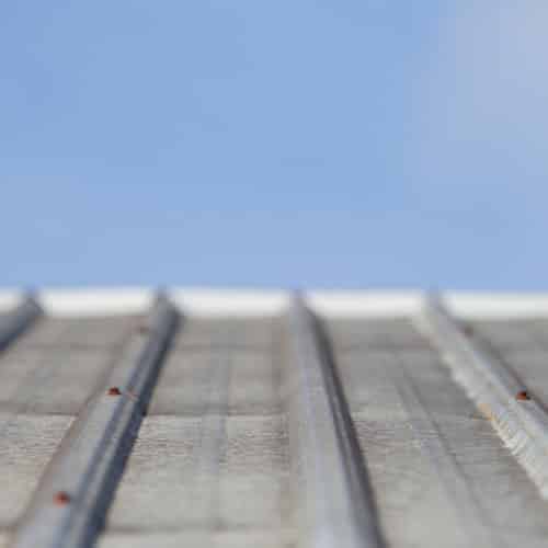 Close up of corrugated iron roofing material against blue sky