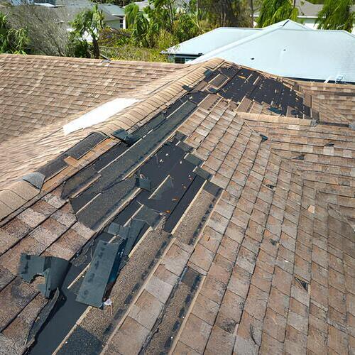 a roofing system damaged by high winds